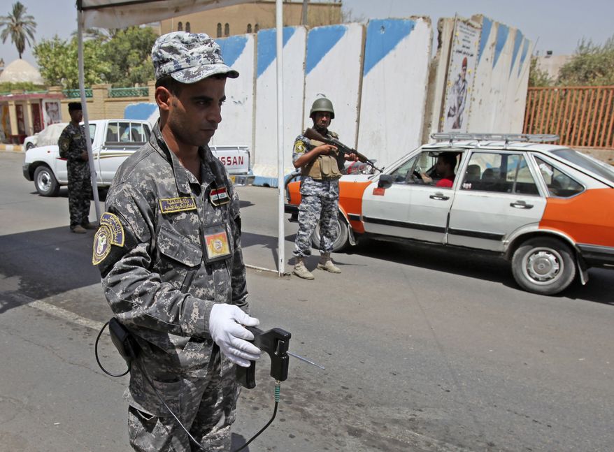 An Iraqi police officer uses a bomb detector at a checkpoint in Baghdad on Sunday, Aug. 29, 2010. (AP Photo/Karim Kadim)