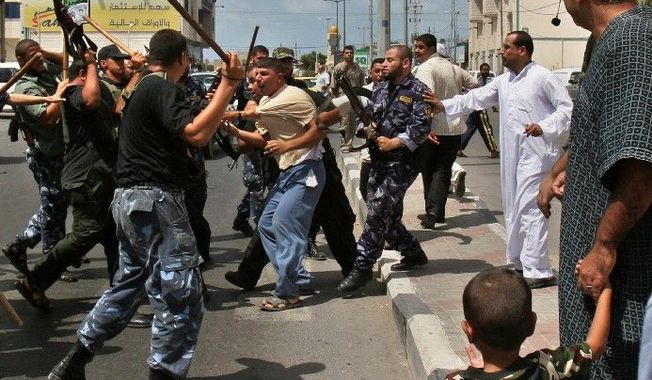 **FILE** Hamas authorities clash with a Fatah supporter in Gaza City. Palestinian rights groups have found a surprising symmetry in abuse between the U.S.-backed government in the West Bank and the Iranian-supported Hamas in Gaza. (Associated Press)