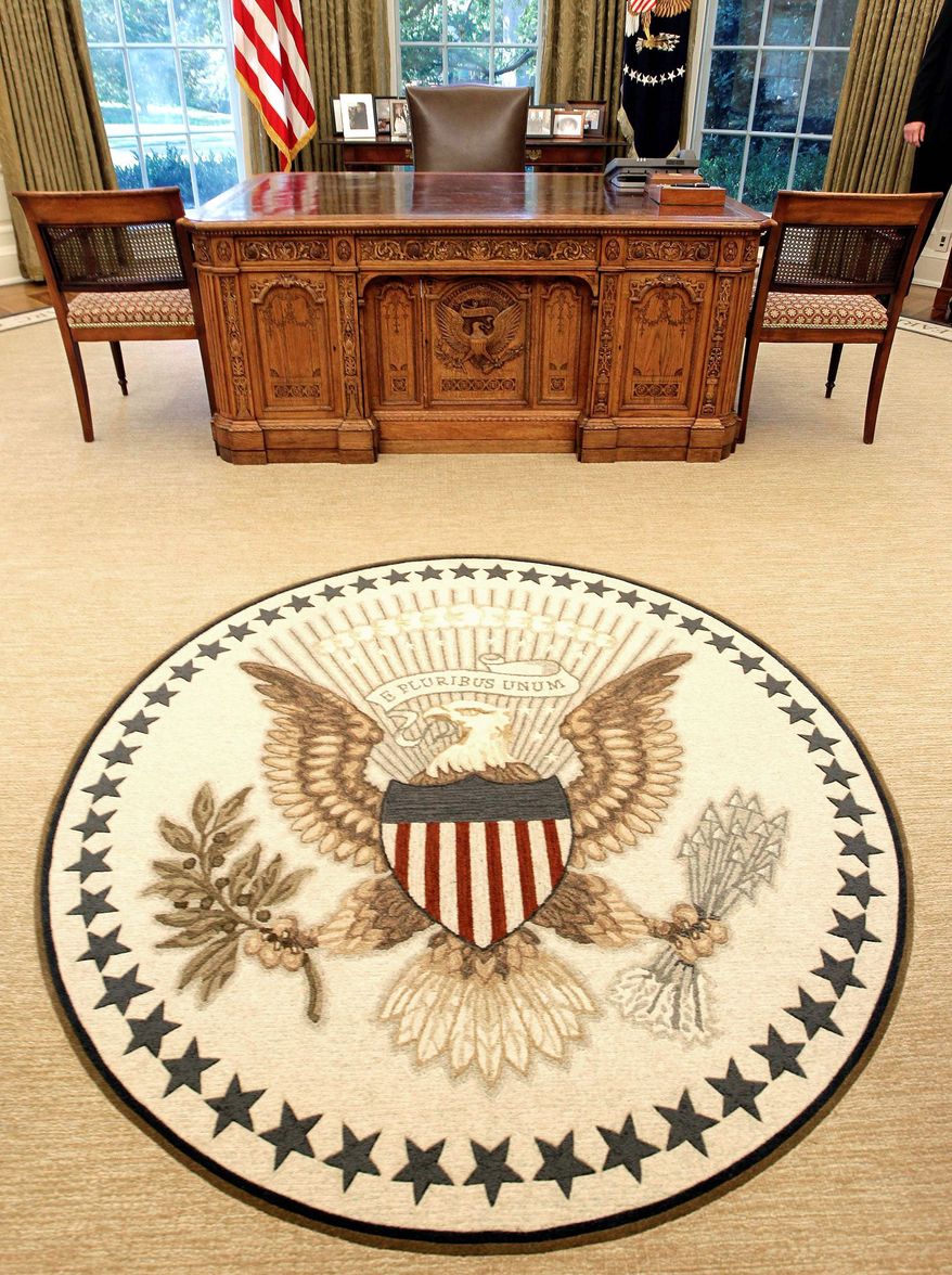 A guest's view of the Oval Office shows the Great Seal of the United States in the middle of a new rug that is bordered with five sayings "of meaning to the president." The famous Resolute Desk remains after renovations.