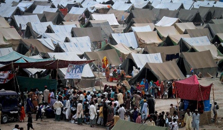TENT CITY: Pakistani families gather to get the evening meal from a food-distribution point in a camp for flood-affected people in Sukkur, Pakistan, on Tuesday. (Associated Press)