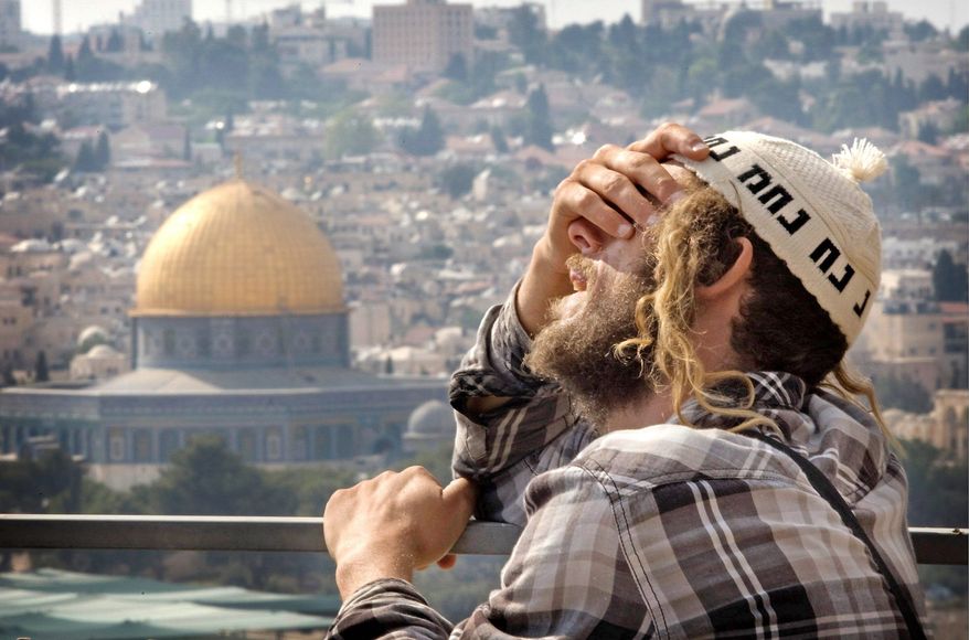 GRIEF: A religious Israeli man reacts during the funeral Wednesday of Yitzhak and Talia Imes, who were killed Tuesday night in a shooting attack near Hebron, outside Jerusalem's Old City. (Associated Press)