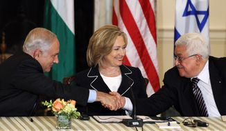 Secretary of State Hillary Rodham Clinton looks on as Palestinian Authority President Mahmoud Abbas, right, and Israeli Prime Minister Benjamin Netanyahu shake hands as she hosts the re-launch of direct negotiations, Thursday, Sept. 2, 2010, at the State Department in Washington. (AP Photo/Charles Dharapak)