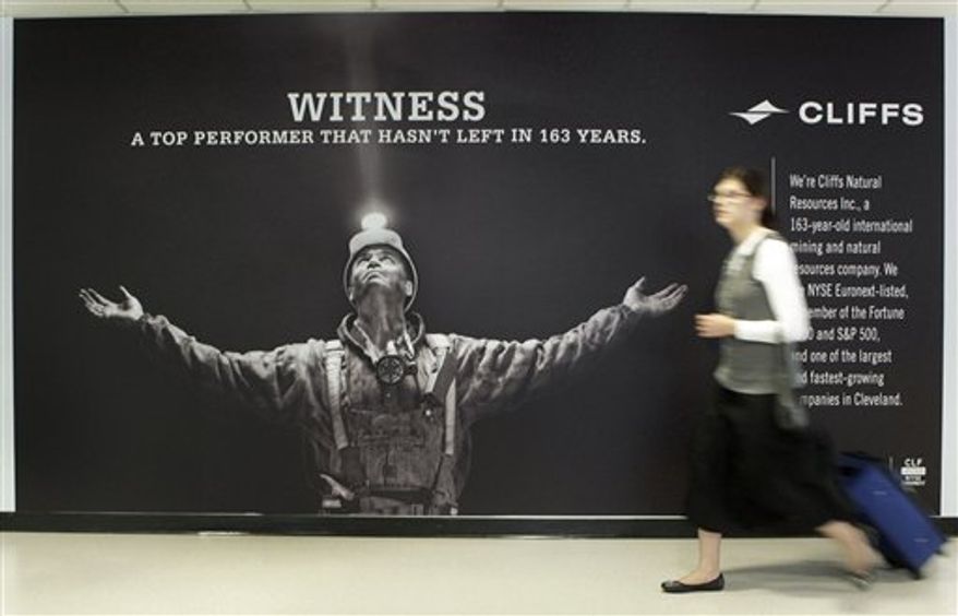 A traveler exiting Concourse C at Cleveland Hopkins Airport walks past a banner for Cliffs Natural Resources Sunday, Aug. 29, 2010. Cliffs, a minerals company with deep roots in Cleveland, launched a publicity campaign Monday to raise its profile in the community at the expense of LeBron James, who bolted the Cleveland Cavaliers for Miami.(AP Photo/Mark Duncan)