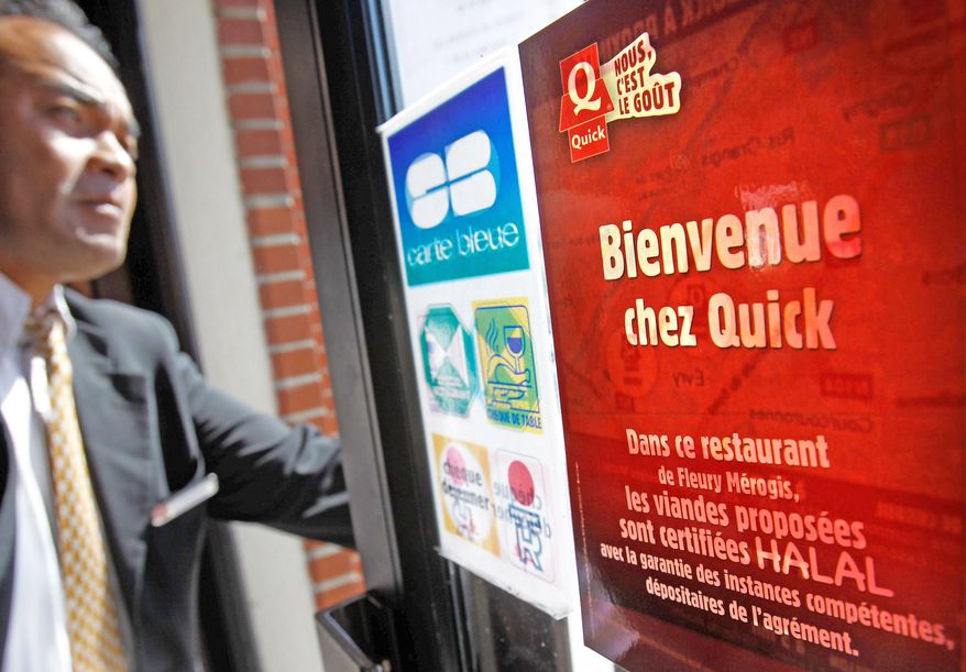 Restaurant manager Patrick Rakotoson stands in his Quick fast-food restaurant in Fleury Merogis, south of Paris, on Wednesday, the first day 22 outlets of the French chain offered halal-beef hamburgers, which look and taste the same as any other. (Associated Press)