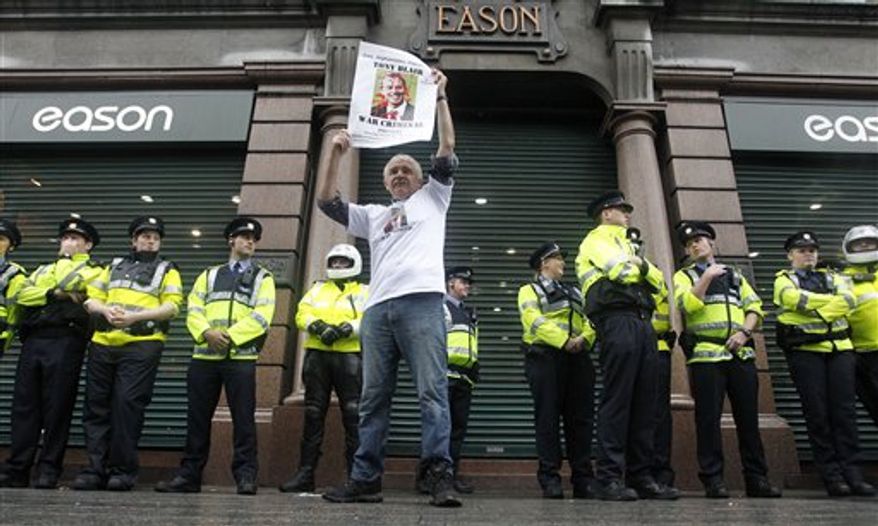 A protester demonstrates outside Eason book store in Dublin, Ireland, as Irish police look on, Saturday, Sept. 4, 2010. Former British Prime Minister Tony Blair appeared for a public book signing at the Eason book store as anti-war protesters hurled shoes and eggs at him as he arrived for his first public signing of his fast-selling memoir. (AP Photo/Peter Morrison)
