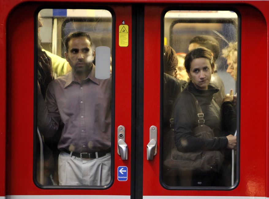 Commuters looks through the window of a subway train in Paris, Tuesday, Sept. 7, 2010. French unions launched a major strike Tuesday over unpopular conservative President Nicolas Sarkozy's plans to raise the retirement age from 60 to 62, with walkouts causing headaches for travelers and commuters. (AP Photo/Thibault Camus)