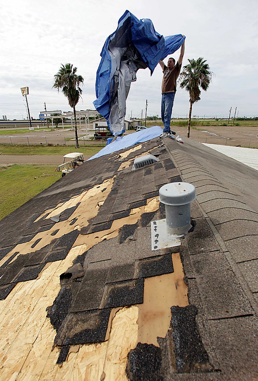 David Anderson covers his damaged roof with a blue tarp, Tuesday, Sept. 7, 2010 in Raymondville, Texas, after tropical storm Hermine swept through the area. (AP Photo/Eric Gay)