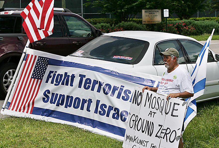 Robert Kunst, of Miami Beach, sits with signs in front of the Dove World Outreach Center in Gainesville on Wednesday, September 8, 2010. Church members there plan to burn copies of the Quran on September 11. Kunst says he is against building a mosque near Ground Zero in New York and is also against the burning of the Qurans. (AP Photo/Orlando Sentinel, Stephen M. Dowell)