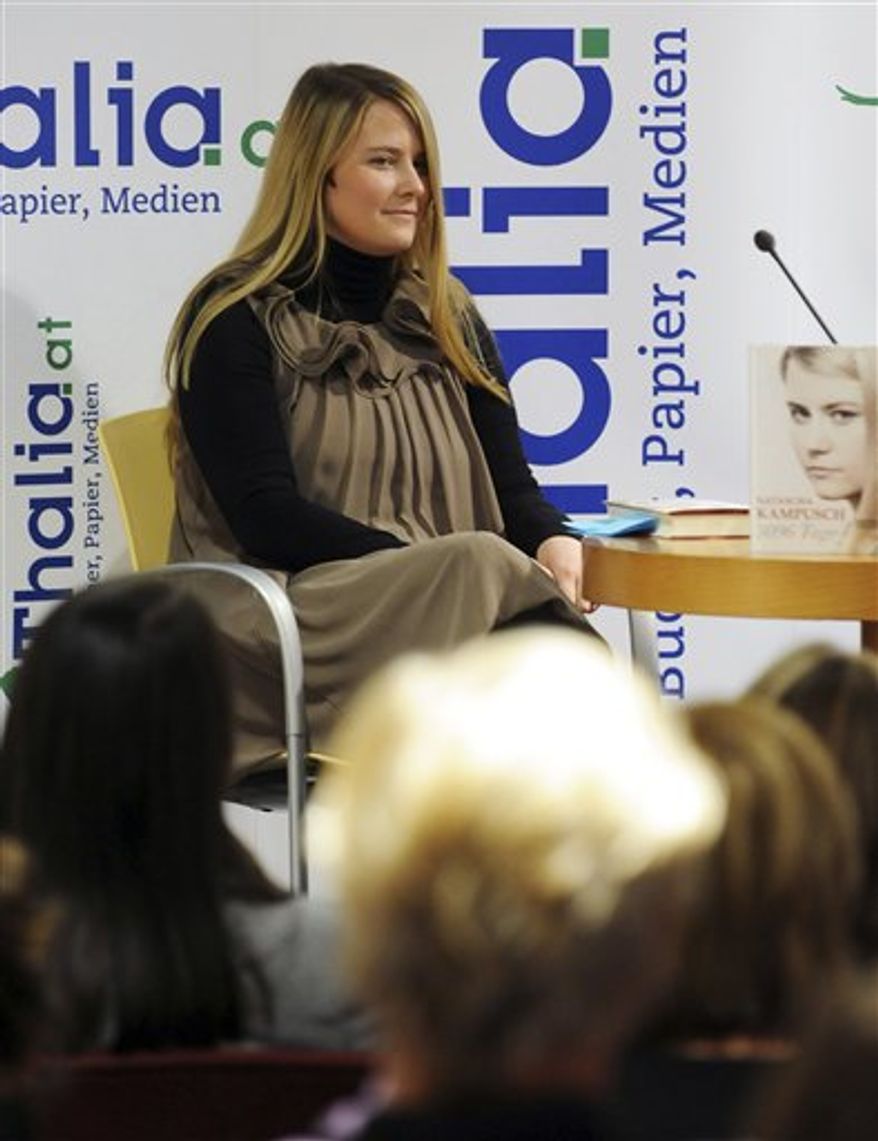 Natascha Kampusch poses with her book "3,096 Tage" (3,096 Days) during a presentation at a book store in Vienna, Austria, on Thursday, Sept. 9, 2010. Kampusch, who was kidnapped at age 10 says she was repeatedly beaten, starved and forced to do housework half-naked during her 8 1/2 years at the mercy of a man who admired Hitler and considered himself an Egyptian god. (AP Photo/Hans Punz)