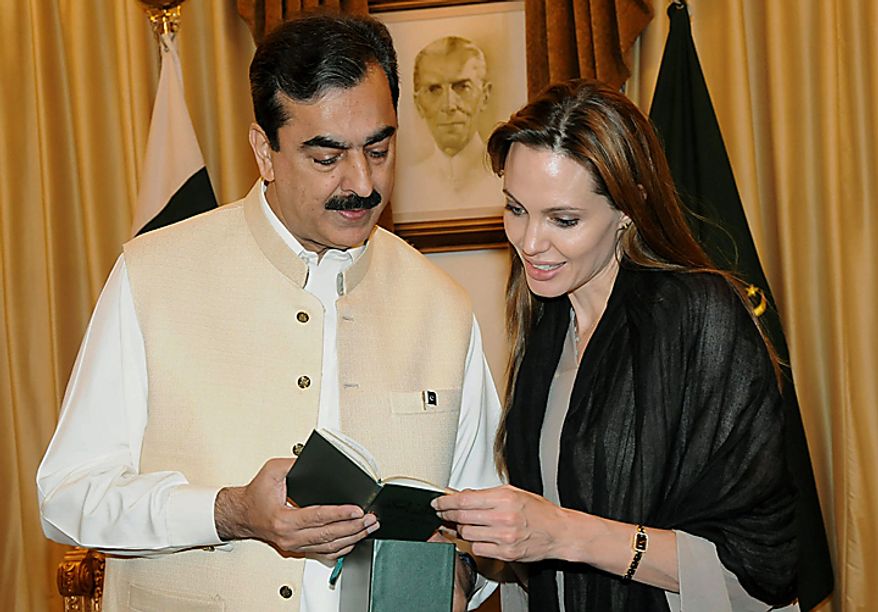 In this photo taken on Wednesday, Sept. 8, 2008, provided by Pakistan's Press Information Department, Pakistan's Prime Minister Yousuf Raza Gilani, left, presents a copy of a Quran to UNHCR Goodwill Ambassador, U.S. actress Angelina Jolie in Islamabad, Pakistan. Jolie on Wednesday condemned a Florida church's threat to burn copies of the Muslim holy book to mark the ninth anniversary of the Sept. 11 attacks. (AP Photo/Press Information Department)