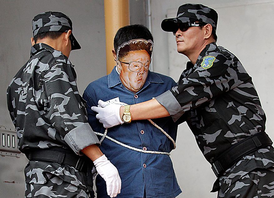 Two North Korean defectors "detain" their fellow playing the role of North leader Kim Jong Il before "execution" during a rally held against pro-North Korean groups in Seoul, South Korea, Thursday, Sept. 9, 2010. North Korea celebrated its 62nd anniversary Thursday with odes to supreme leader Kim Jong Il and pilgrimages to his late father's statue amid hints that a political meeting believed aimed at promoting his son as successor is imminent. (AP Photo/ Lee Jin-man)