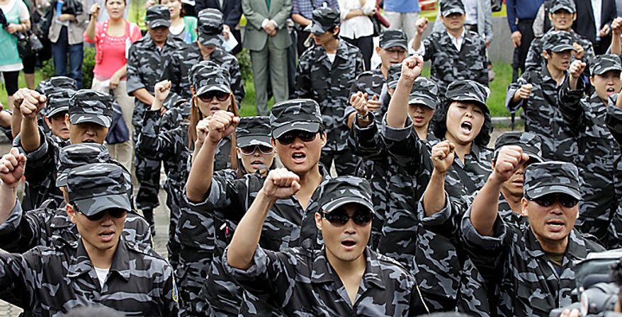 North Korean defectors wearing military uniforms shout slogans during the launching ceremony of the North Korea People Liberation Front, a group intend to fight against North Korea leader Kim Jong Il, in Seoul, South Korea, Thursday, Sept. 9, 2010. North Korea celebrated its 62nd anniversary Thursday with odes to supreme leader Kim Jong Il and pilgrimages to his late father's statue amid hints that a political meeting believed aimed at promoting his son as successor is imminent. (AP Photo/ Lee Jin-man)
