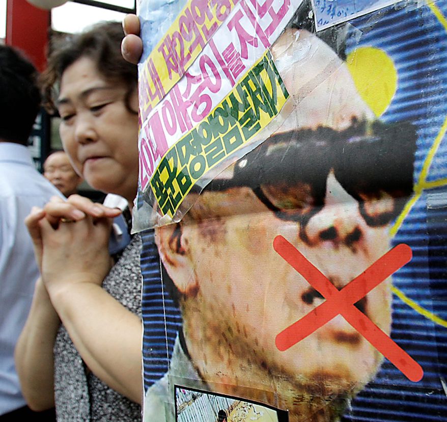 A woman reacts near a picture of North Korea leader Kim Jong Il during a rally held against pro-North Korean groups in Seoul, South Korea, Thursday, Sept. 9, 2010. The youngest son of Kim Jong Il is widely expected to make his public debut as the Dear Leader's heir apparent at a rare Workers' Party convention, the nation's biggest political gathering in 30 years. (AP Photo/ Lee Jin-man)