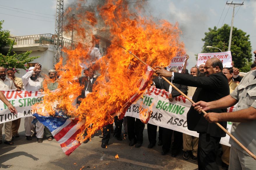 Pakistani lawyers burn a U.S. flag while rallying in reaction to a small American church's plan to burn copies of the Koran in Multan, Pakistan, on Thursday, Sept. 9, 2010. (AP Photo/Khalid Tanveer)