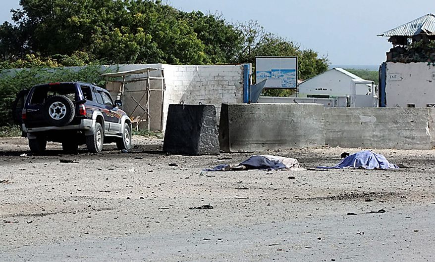 Two bodies lie in front of the Mogadishu airport gate Thursday, Sept. 9, 2010. A suicide car bomber and gunmen attacked the front gate to Mogadishu's seaside airport on Thursday, triggering an explosion and gunbattle, officials said. Several people were killed, including security forces. The coordinated attack was the latest in a surge of assaults by Islamist insurgents, who last month declared a new, stepped-up effort to oust the country's weak government. The barrage took place about 40 minutes after Somalia's president flew out of the country. After the car bomb exploded, a second vehicle full of militants opened fire at African Union and Somali security forces, said Osman Dahir, a police officer at the airport. He said there were several dead bodies of insurgents lying in front of the airport, but he didn't know how many.(AP Photo/Farah Abdi Warsameh)