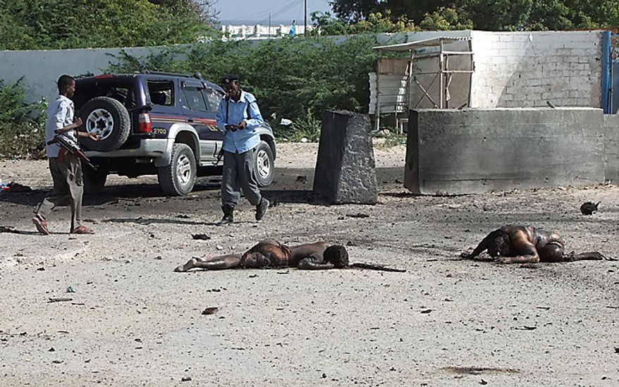 Two bodies lie in front of the Mogadishu airport gates Thursday, Sept. 9, 2010. A suicide car bomber and gunmen attacked the front gate to Mogadishu's seaside airport on Thursday, triggering an explosion and gun battle, officials said. Several of people were killed, including security forces. The coordinated attack was the latest in a surge of assaults by Islamist insurgents, who last month declared a new, stepped-up effort to oust the country's weak government. The barrage took place about 40 minutes after Somalia's president flew out of the country. After the car bomb exploded, a second vehicle full of militants opened fire at African Union and Somali security forces, said Osman Dahir, a police officer at the airport. He said there were several dead bodies of insurgents lying in front of the airport, but he didn't know how many. (AP Photo/Farah ASbdi Warsameh)