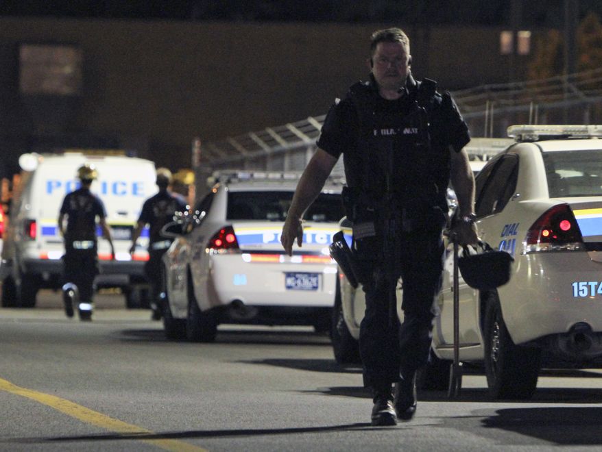 ** FILE ** A S.W.A.T. officer exits the scene of a workplace shooting at the Kraft Foods Inc. facility in Northeast Philadelphia on Sept. 9, 2010. (AP Photo/ Joseph Kaczmarek)