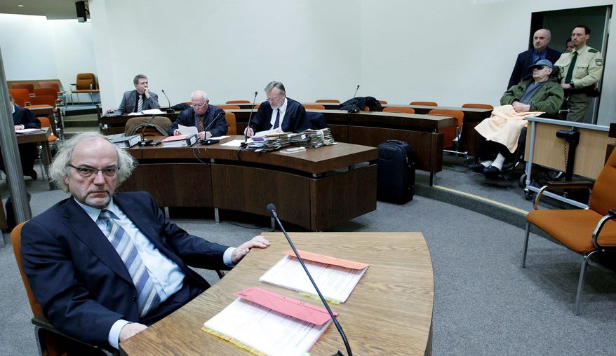 Judge Thomas Walther (left) waits as defendant John Demjanjuk (right) enters the courtroom in a wheelchair in February for a session in Munich. Judge Walther is one of the key figures in the decision to try Mr. Demjanjuk, who is the first non-German alleged Nazi collaborator to stand trial in a German court. His trial resumes this week in Munich after a summer break. (Associated Press)