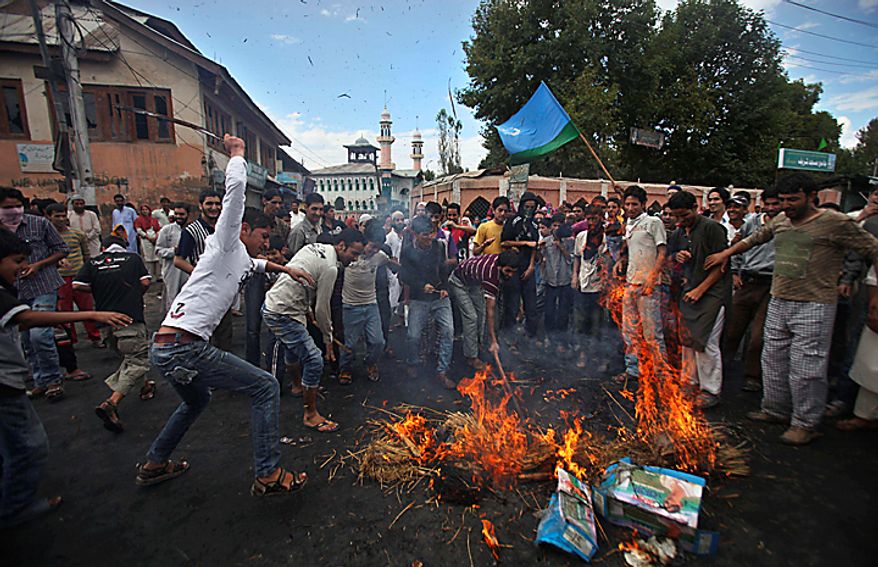 Kashmiri protesters beat the remains of an effigy of U.S. President Barack Obama after burning it during a protest in Srinagar, India, Monday, Sept. 13, 2010. Indian forces battled Kashmiri protesters in the streets of the disputed territory Monday in demonstrations fueled in part by a report of the Quran being desecrated in the United States. (AP Photo/Altaf Qadri)