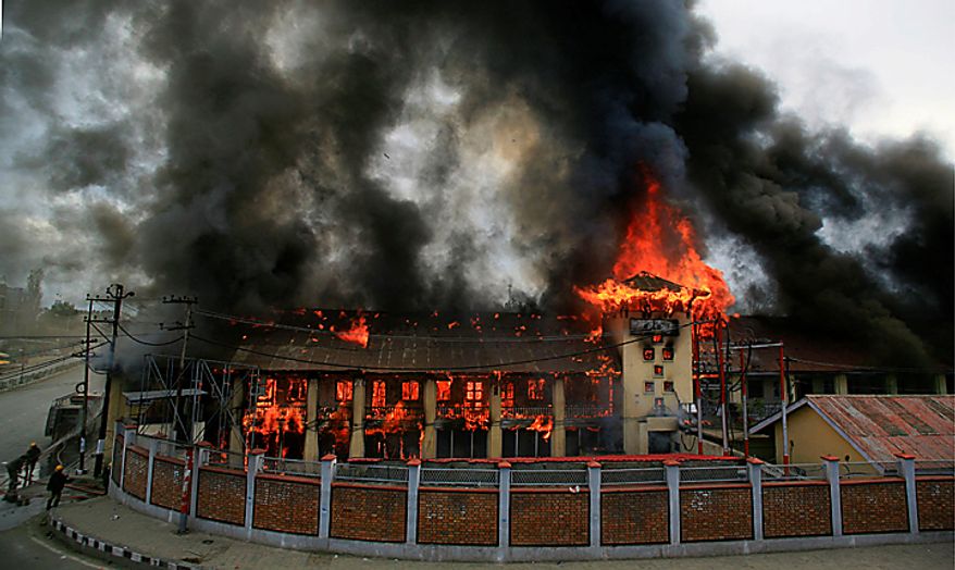 Firefighters try to douse flames at a government building set on fire by protesters in Srinagar, India, Saturday, Sept. 11, 2010. Police fired warning shots and tear gas to disperse hundreds of demonstrators who attacked a police post and burned government offices in Kashmir on Saturday, as tens of thousands of people took to the streets to protest Indian rule in the Himalayan region, officials said. (AP Photo/Altaf Qadri)