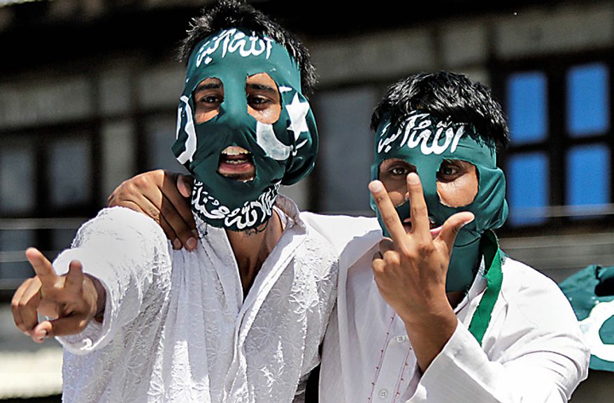 Masked Kashmiri protesters display the victory sign during a protest rally after Eid al-Fitr prayers in Srinagar, India, Saturday, Sept. 11, 2010. Police fired warning shots and tear gas to disperse hundreds of demonstrators who attacked a police post and burned government offices in Kashmir on Saturday, as tens of thousands of people took to the streets to protest Indian rule in the Himalayan region, officials said. Scarf reads "Allah is great," top, and "There is no God but Allah and Prophet Mohammad is his messenger," bottom. (AP Photo/Dar Yasin)