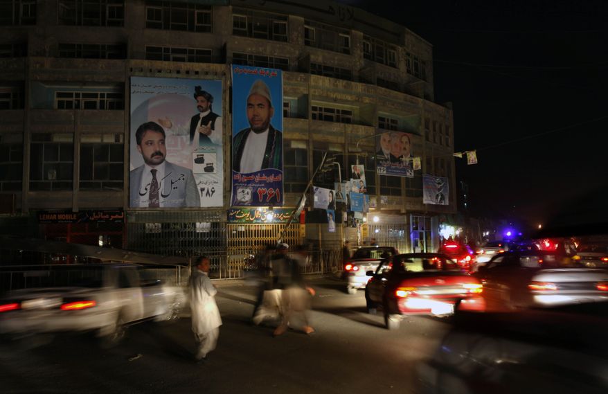Afghans walk between traffic past posters of parliamentary candidates in Kabul, Afghanistan, Tuesday, Sept. 14, 2010. Fears of violence hang over Saturday's elections. (AP Photo/ Mustafa Quraishi)