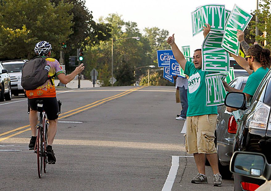 Adrian Fenty and Vince Gray volunteers cheer at a passing bicyclist outside a polling place in Washington, Tuesday, Sept. 14, 2010, as voters cast their ballots in the District of Columbia primaries. (AP Photo/Ann Heisenfelt)