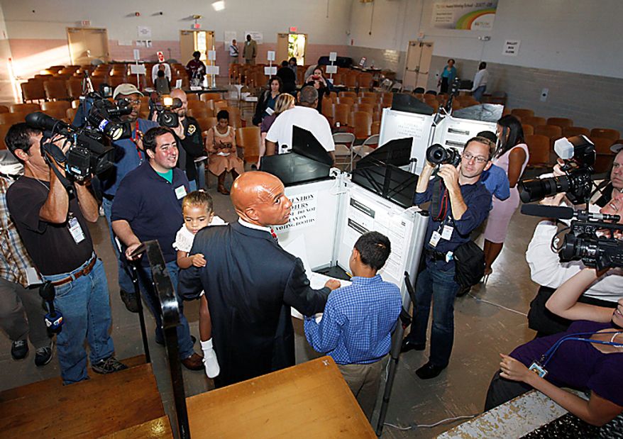 Washington Mayor Adrian Fenty is surrounded by cameras as he casts his vote in Washington, Tuesday, Sept. 14, 2010, as Washington held its mayoral primary. (AP Photo/Ann Heisenfelt)