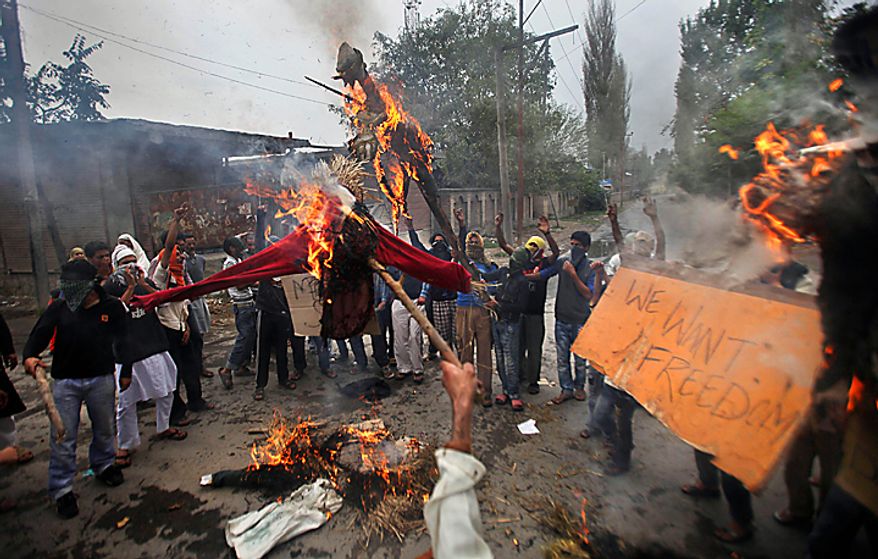 Kashmiri protesters shout slogans as they burn effigies of Indian prime minister and the Jammu and Kashmir state chief minister in Srinagar, India, Tuesday, Sept. 14, 2010. Indian police patrolled the streets of Kashmir on Tuesday, threatening to shoot anyone defying a rigid curfew imposed on the region a day after troops battled protesters in the streets in violence that killed 19 people. (AP Photo/Altaf Qadri)