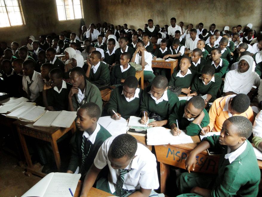 Students crowd a biology class at Msaranga Secondary School near Moshi, Tanzania, where youngsters hunger for education. To get into the classroom, however, they have to pay substantial fees for items such as uniforms and desks. (Associated Press)