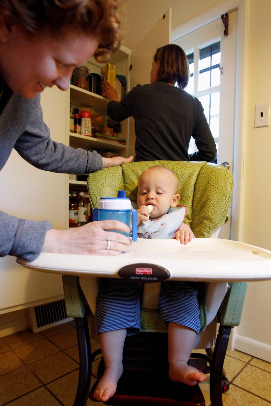 Associated Press
Cara Palladino (left) and Isabelle Barker (background) feed their son, Will Palladino, 1, at their home in Philadelphia in April. Nontraditional households like theirs are the subject of a new study.