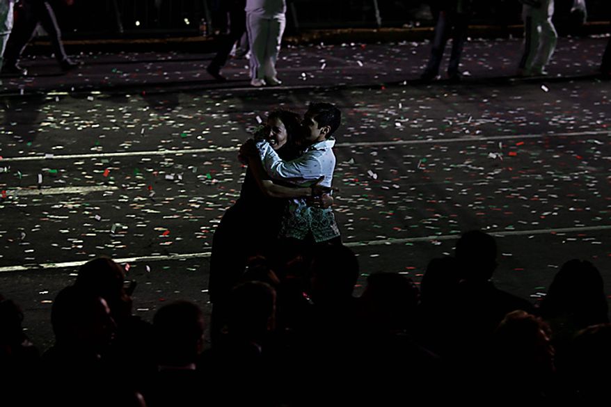 Performers embrace during bicentennial celebrations in Mexico City's main Zocalo plaza, Wednesday Sept. 15, 2010. Mexico celebrates the 200th anniversary of its 1810 independence uprising. (AP Photo/Dario Lopez-Mills)