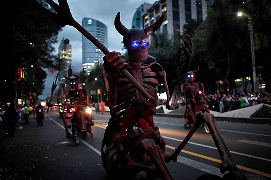 People dressed as horned skeletons cycle during the bicentennial parade in Mexico City, Wednesday Sept. 15, 2010. Mexico celebrates the 200th anniversary of its 1810 independence uprising. (AP Photo/Miguel Tovar)