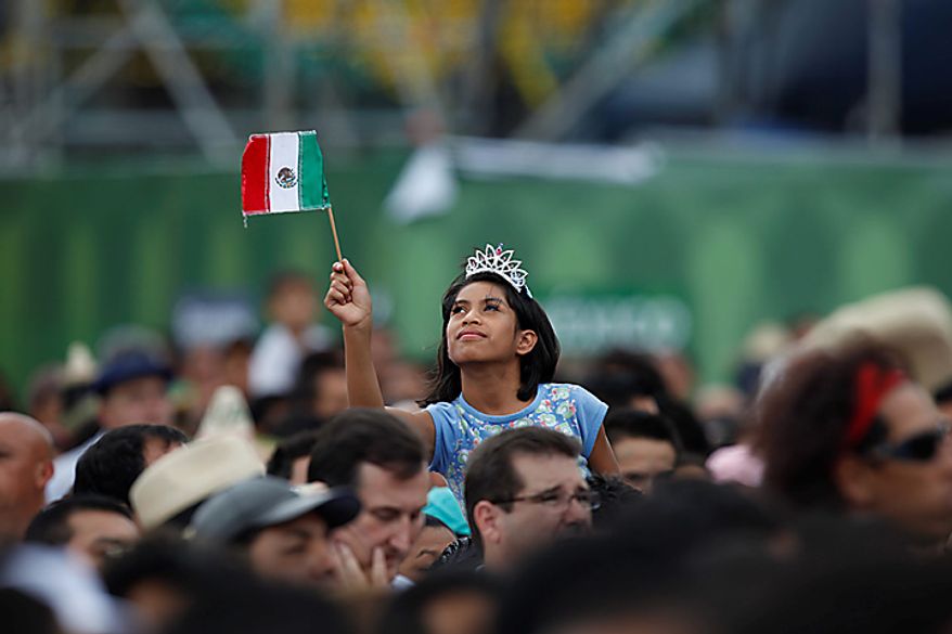 A person waves a Mexican flag during bicentennial celebrations at the Zocalo plaza in Mexico City, Wednesday Sept. 15, 2010. Mexico celebrates the 200th anniversary of its 1810 independence uprising. (AP Photo/Alexandre Meneghini)