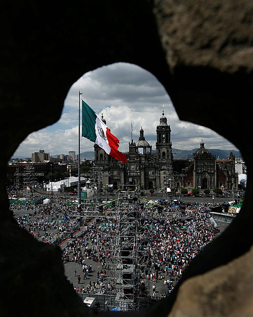 People begin to gather in Mexico City's downtown Zocalo plaza for bicentennial celebrations, Wednesday Sept. 15, 2010. Mexico celebrates the 200th anniversary of its 1810 independence uprising. (AP Photo/Marco Ugarte)