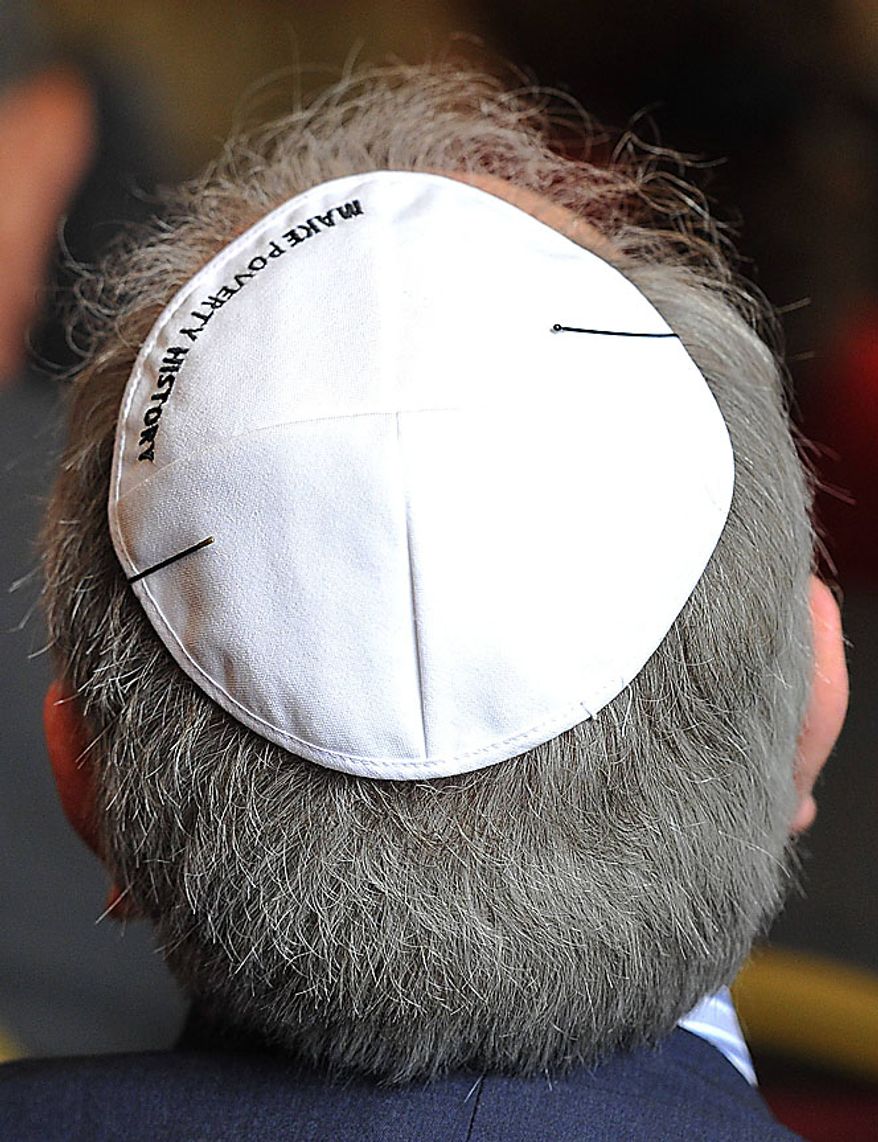A member of the audience wears a Yarmulke with the message "Make Poverty History" embroidered on it as he watches as Pope Benedict XVI attends a meeting of religious leaders at St Mary's University College Chapel at Twickenham in west London, Friday, Sept. 17, 2010. The Pope is on a four-day visit to England and Scotland. (AP Photo/Toby Melville, Pool)