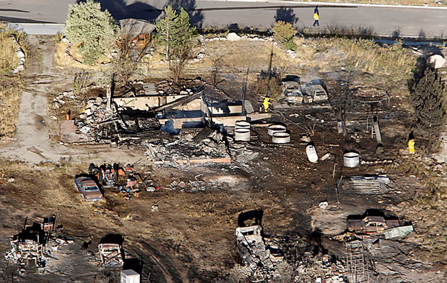 One of the four confirmed homes that was destroyed by fire in Herriman, Utah on Monday, Sept. 20, 2010. A wind-stoked wildfire sparked at a firing range during a National Guard training session blazed across thousands of acres Monday as crews rushed to keep it from burning more than four homes that were destroyed overnight. The fire moved back on itself Monday as the Utah National Guard acknowledged it wasn't the first time that live-fire exercises had sparked a fire at Camp Williams, a sprawling compound 30 miles south of Salt Lake City. (AP Photo/Scott G Winterton, Pool)