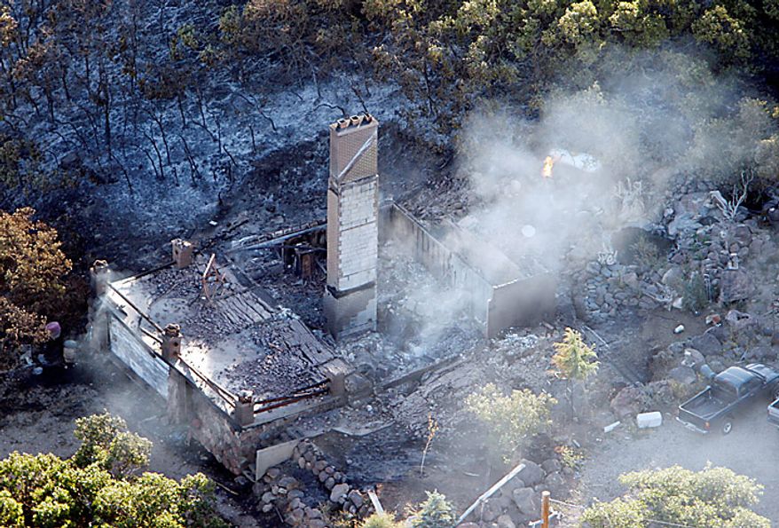 A home that was destroyed by the fire is shown in Herriman, Utah on Monday, Sept. 20, 2010. A wind-stoked wildfire sparked at a firing range during a National Guard training session blazed across thousands of acres Monday as crews rushed to keep it from burning more than four homes that were destroyed overnight. The fire moved back on itself Monday as the Utah National Guard acknowledged it wasn't the first time that live-fire exercises had sparked a fire at Camp Williams, a sprawling compound 30 miles south of Salt Lake City. (AP Photo/Scott G Winterton, Pool)