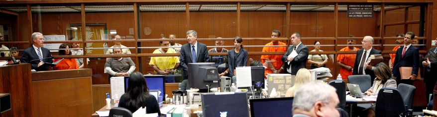 ASSOCIATED PRESS
Current and former Bell, Calif., city officials accused of corruption stand in the background Wednesday during a Los Angeles court hearing. From left are: Teresa Jacobo, Angela Spaccia, Robert Rizzo, Victor Bello, George Cole, Luis Artiga, Oscar Hernandez, and George Mirabal.
