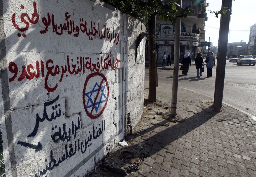 **FILE** Graffiti on a wall on a main commercial street in Gaza City, Gaza Strip, on Sept. 21, 2010, reads in Arabic: "The Interior Ministry and National Security, and the Campaign to battle collaboration with the enemy, thank the Union of Palestinian artists." A Hamas campaign to catch Palestinians spying for Israel has trawled in prominent Gaza residents, prompting some of the sharpest public criticism of the territory's Islamic militant rulers since they seized power more than three years ago. (Associated Press)