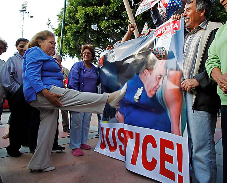 A woman aims a kick at an image of former City Manager Robert Rizzo, made during his arrest early Tuesday at his Huntington Beach home, as residents of the city of Bell, Calif., celebrate the arrest of current and former city officials on corruption charges, outside City Hall Tuesday, Sept. 21, 2010. (AP Photo/Reed Saxon)