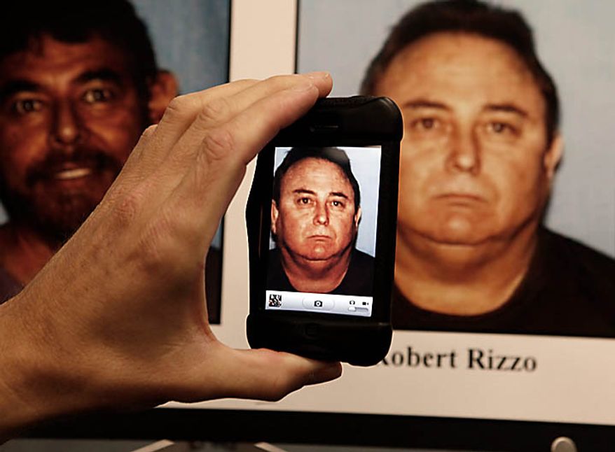 A member of the media uses a telephone to take a picture of a mug shot of Bell, Calif.'s former city manager, Robert Rizzo who was arrested Tuesday Sept. 21, 2010 and displayed during a district attorney news conference in Los Angeles. Rizzo and seven other city officials were arrested over allegations of corruption, misuse of public funds and voter fraud. (AP Photo/Nick Ut)