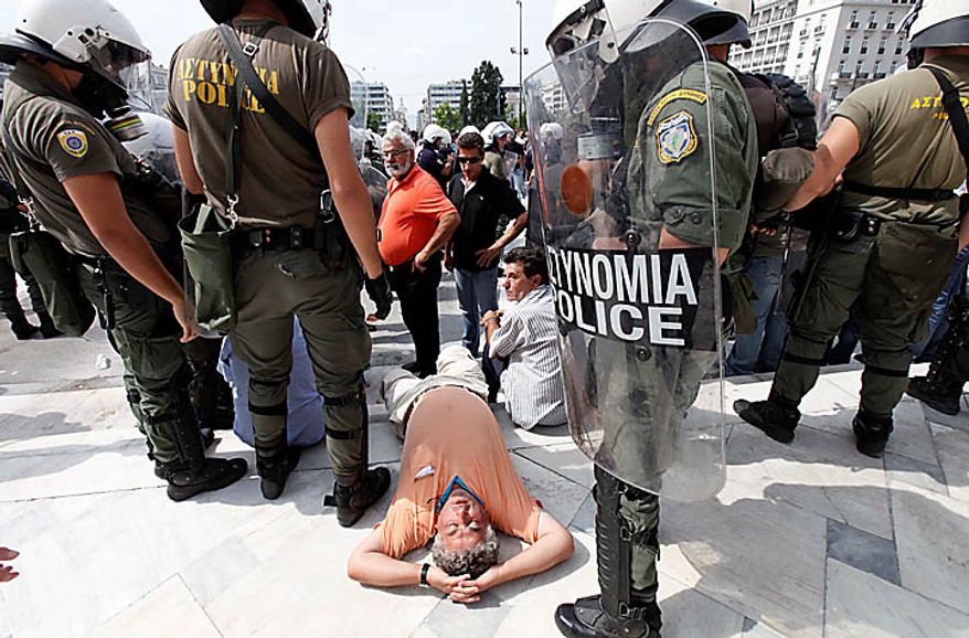 A truck lies down in protest in front of riot police offices during a demonstration outside the Greek Parliament in Athens, Wednesday, Sept. 22, 2010. Truckers strongly oppose government plans to reform their sector and abolish strict licensing rules. (AP Photo/Dimitri Messinis)