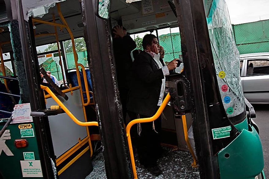 Two ultra-Orthodox Jewish men, one injured, and a bus driver look out from a bus after it was vandalized by Palestinian rioters outside Jerusalem's Old City, Wednesday, Sept. 22, 2010. Violence erupted after a 32-year-old Palestinian laborer was killed by a private security guard watching over Jewish families in the Silwan neighborhood in east Jerusalem. During the man's funeral, a mob of protesters set tires on fire, smashed the windows of several buses and called for revenge. (AP Photo/Bernat Armangue)