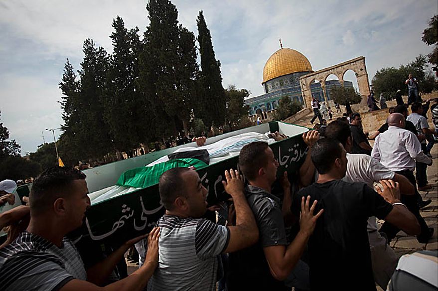 Palestinian mourners carry the coffin of Sami Sirhan during his funeral in Jerusalem's Old City, with the Dome of the Rock seen in the background, Wednesday, Sept. 22, 2010. Sirhan, a 32-year-old Palestinian laborer was killed by a private security guard watching over Jewish families in the Silwan neighborhood in east Jerusalem. During his funeral, a mob of protesters set tires on fire, smashed the windows of several buses and called for revenge. (AP Photo/Bernat Armangue)