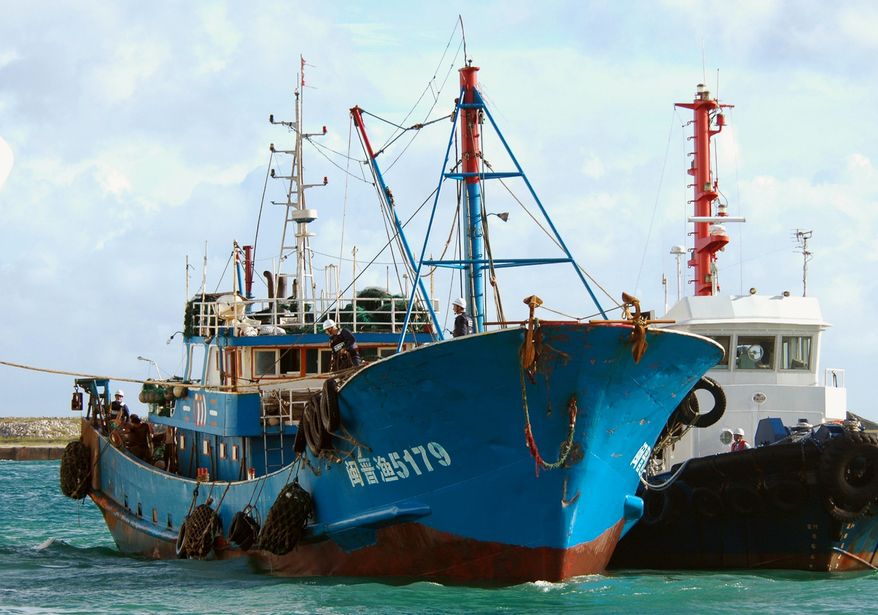 In this photo from Sept. 8, 2010, a Chinese fishing boat (left), which was involved in a collision near disputed islands, arrives at a port on Ishigaki island, Okinawa prefecture, southwestern Japan. Japanese prosecutors decided Sept. 24, 2010, to release the captain of the Chinese fishing boat, whose detention raised tensions between the Asian neighbors. (Associated Press/Kyodo News)