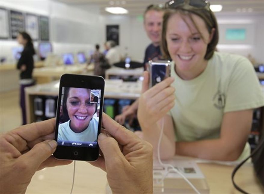 In this Sept. 9, 2010 photo, a customer tests the new Apple iPod Shuffle on display at an Apple Store in Palo Alto, Calif. (AP Photo/Paul Sakuma)