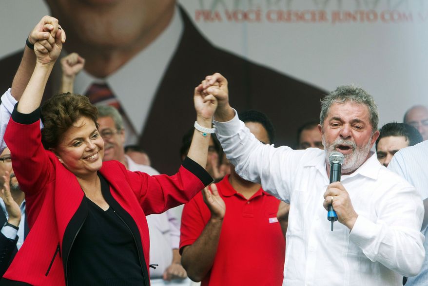 Brazilian President Luiz Inacio Lula da Silva gives a hand to his choice as his successor, Dilma Rousseff, during a campaign rally in Campinas on Sept. 18. (Associated Press)