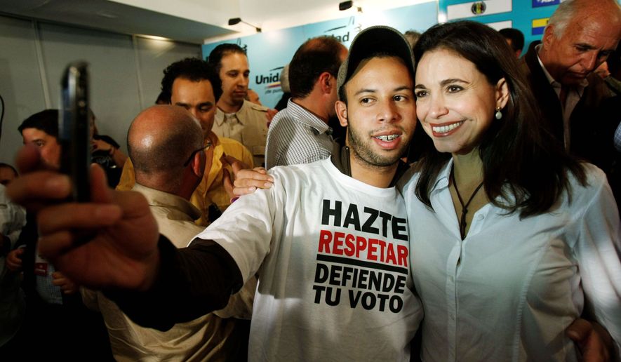 RISING STAR: Independent activist Maria Corina Machado poses with a supporter Monday after being elected to Venezuela&#39;s National Assembly. She has been touted as a challenger to President Hugo Chavez. (Associated Press)