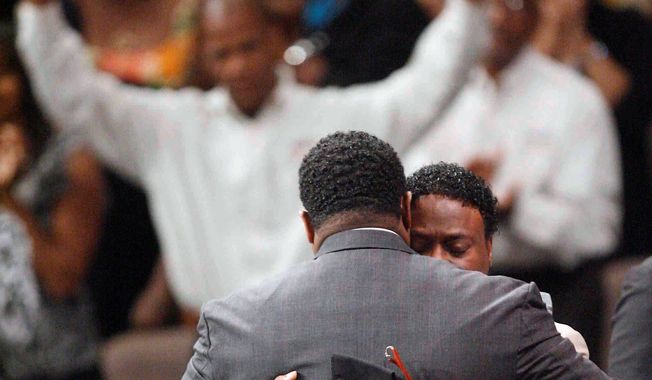 Bishop Eddie Long (right), embraces a friend at a Sunday service in Atlanta. He did not directly deny accusations of sexually seducing young men. (Associated Press)